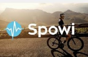 Weißer Schriftzug „Spowi“ mit blauem Kreis und Pulswelle, darüber eine Radfahrerin auf einer Bergstraße bei Sonnenuntergang.