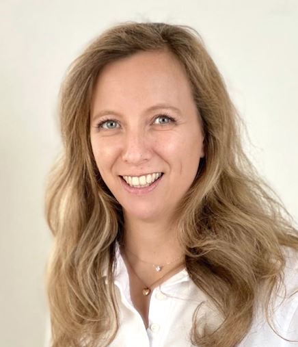 OÄ Dr. Nadja Jiresch lächelnd mit weissem Arztkittel vor beigem Hintergrund